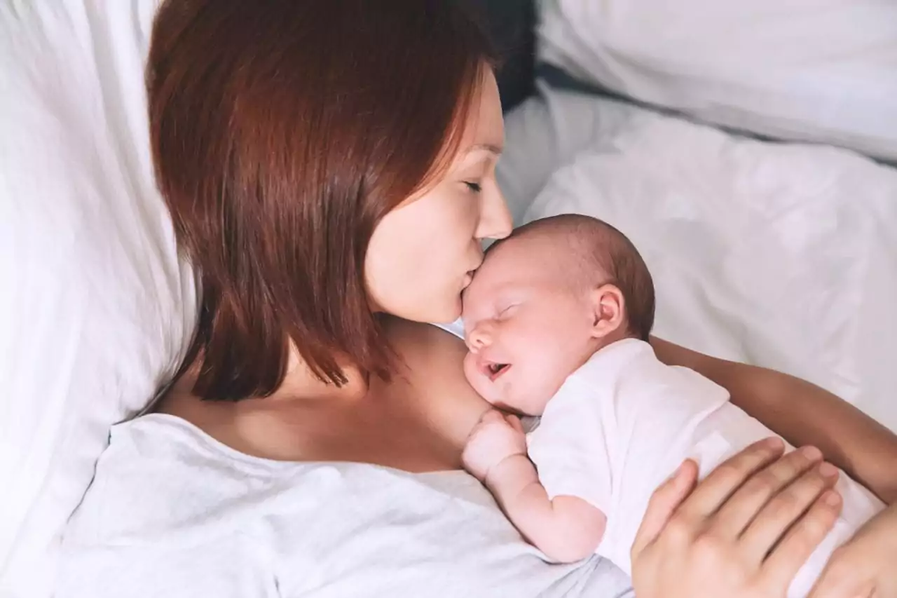 mother kissing newborn baby 1280x853