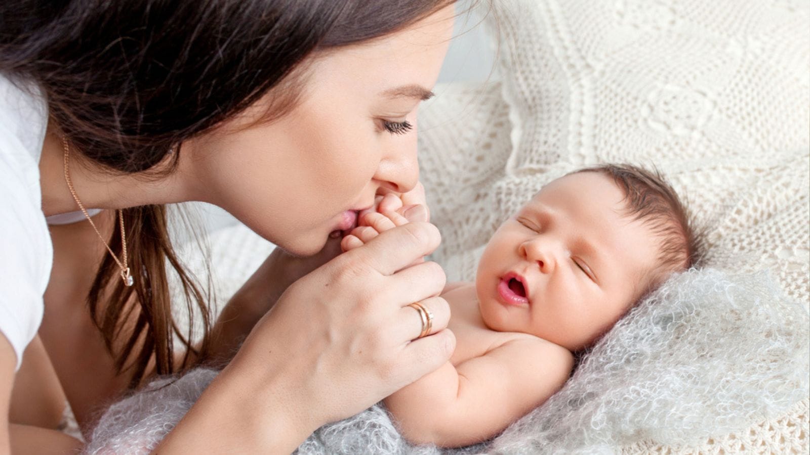 pretty woman holding a newborn baby in her arms.